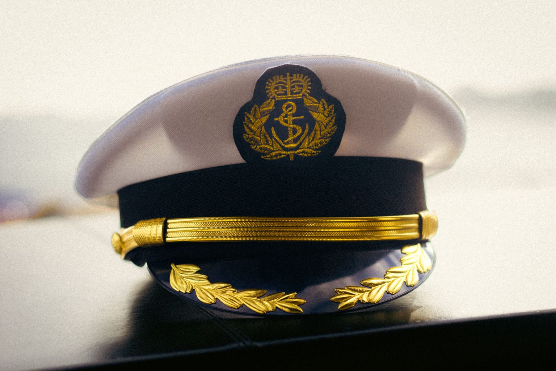 Quepe de oficial com bordado dourado sobre uma mesa